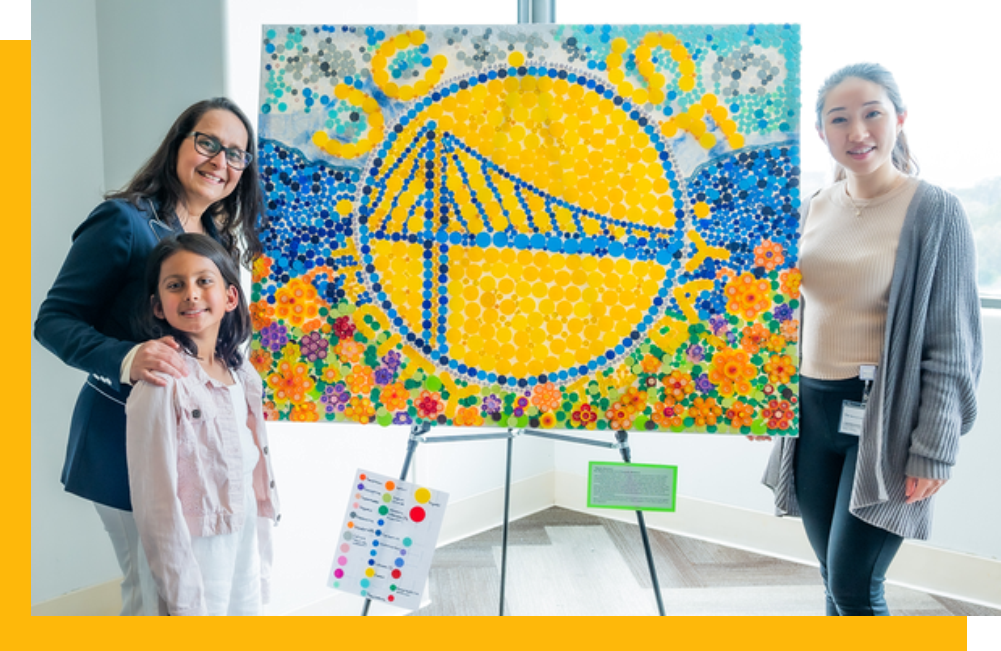 Dr. Seema Gandhi and daughter Maya with Kaiyi and the 2023 Waste to Art sustainable artwork entry made from anesthesia drug vial caps
