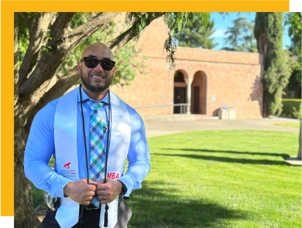 Mark Bautista outside at his MBA graduation sash 