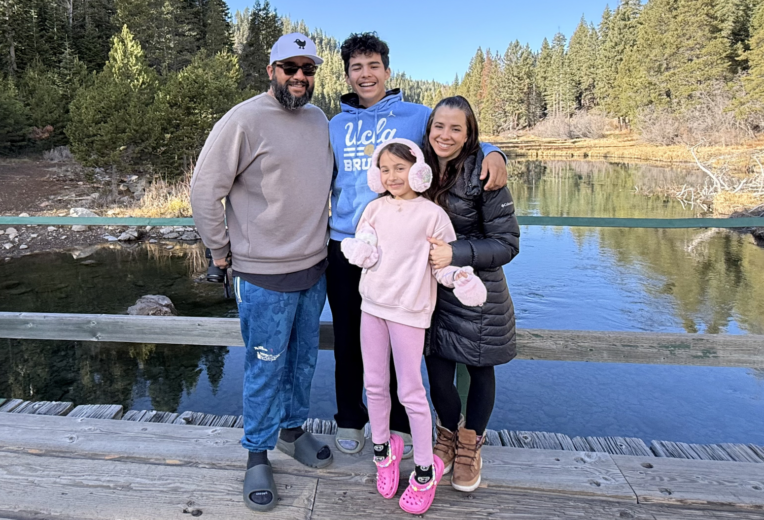 Marcia Soares, husband, son and daughter, outside with water in the background