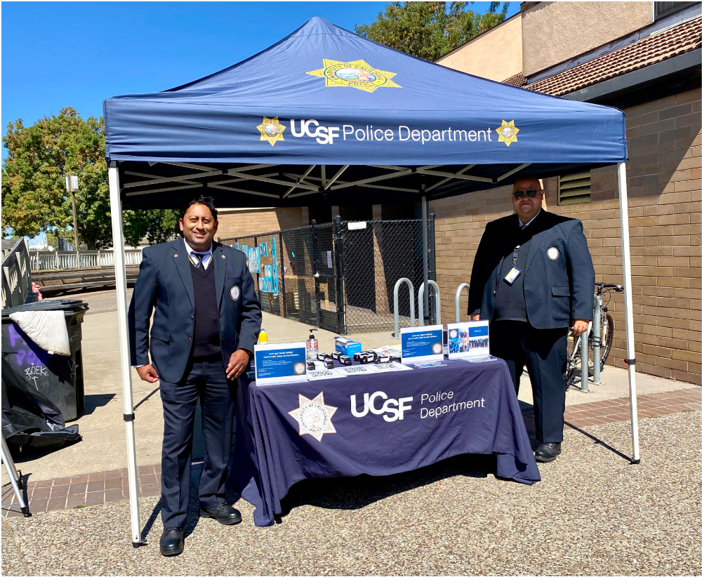 Ricky at a UCSF Police Department table with tent at an event 
