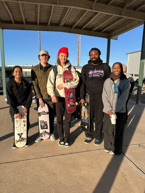 Five members of the Skateboard Club at UCSF outside at a volunteer event for SkateMD  
