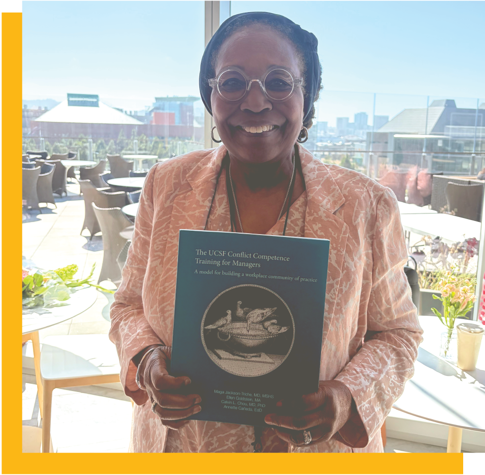Maga Jackson-Triche, MD, MSHS holding her book at a UCSF book launch celebration